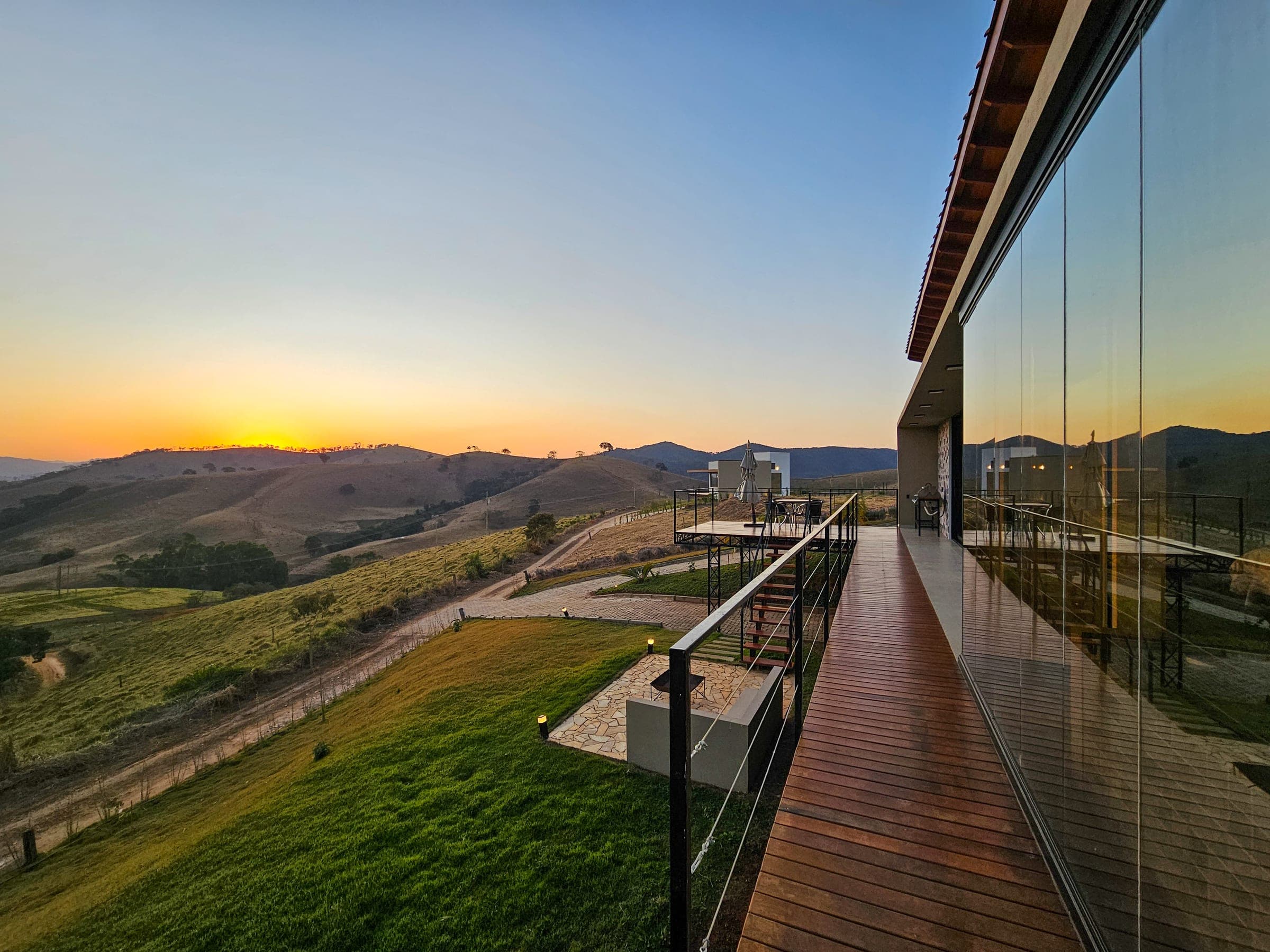 Deck de vidro do Solarium 1 ao pôr do sol, com o Solarium 2 no vale